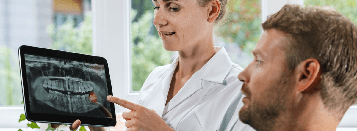 Dentist Explaining Dental X-Ray To Patient